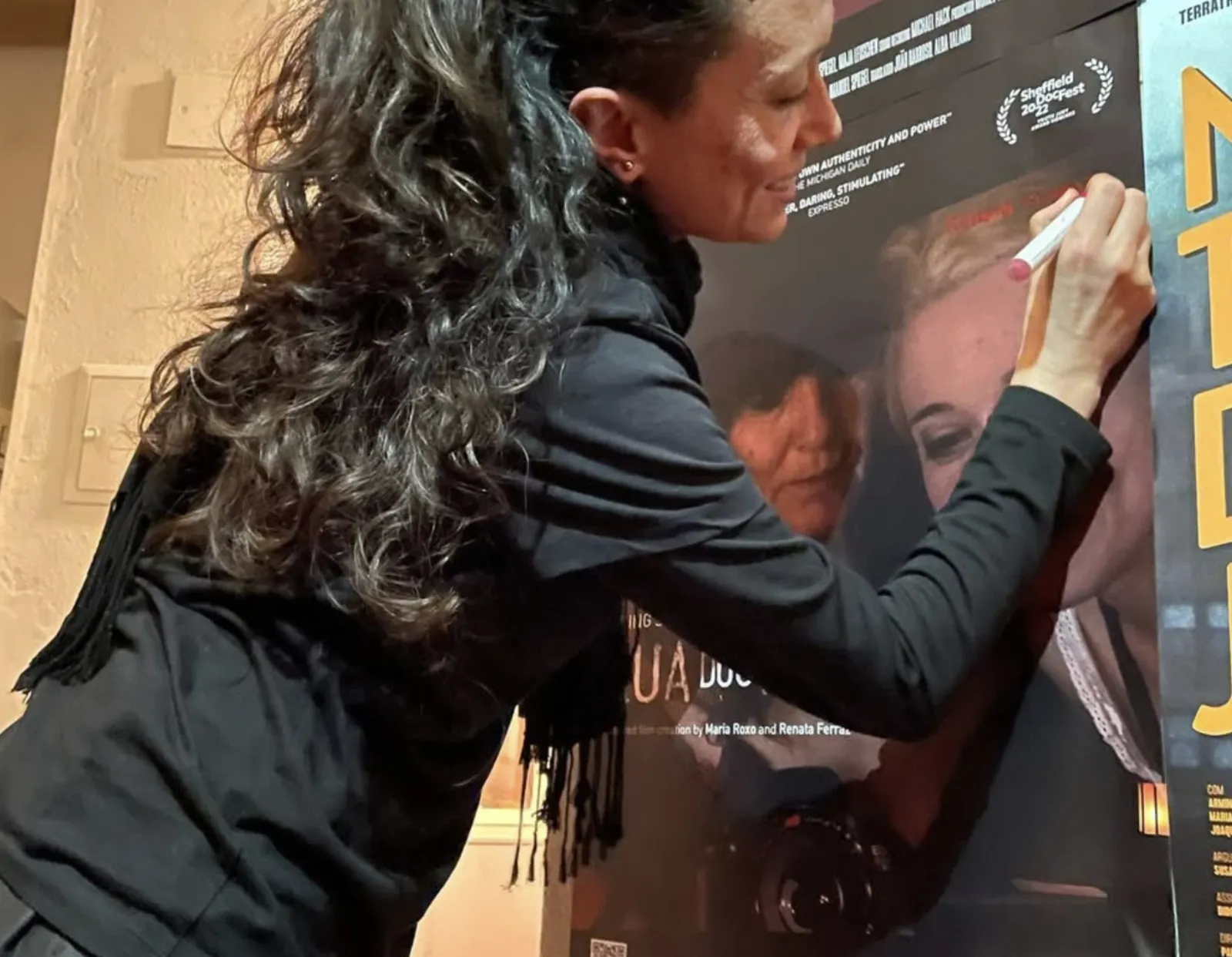 Signing the poster for Rua dos Anjos