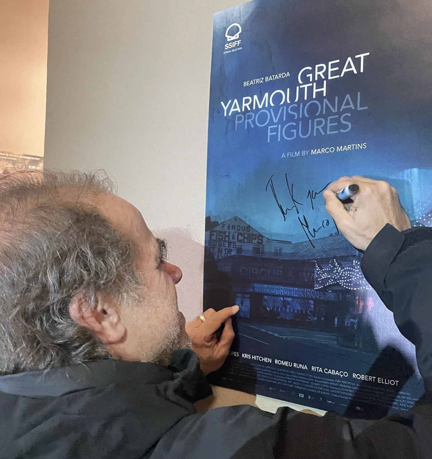 Marco Martins signs the poster for Great Yarmouth: Provisional Figures