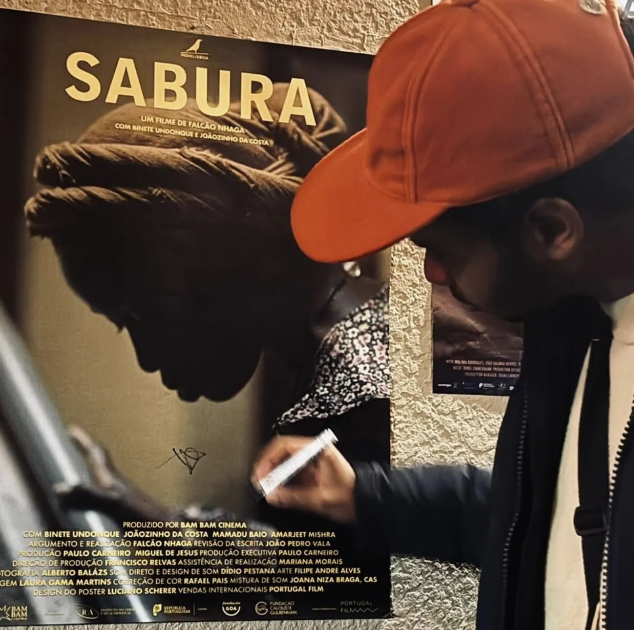 Falcão Nhaga signs the poster for Sabura