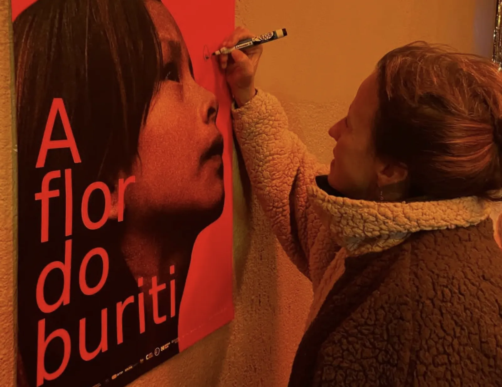 Signing the poster for A Flor do Buriti